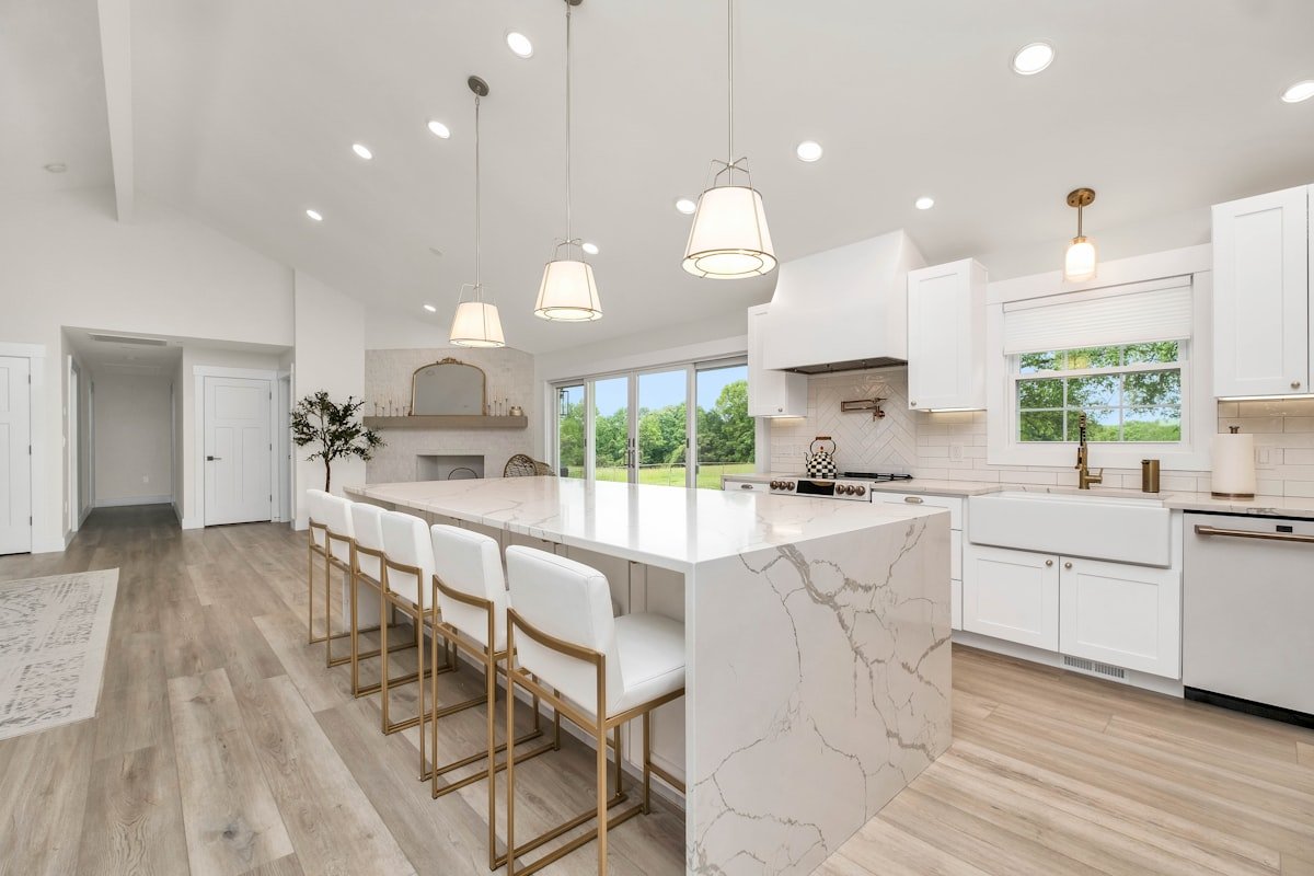 A spotless modern kitchen with a marble island and white cabinetry